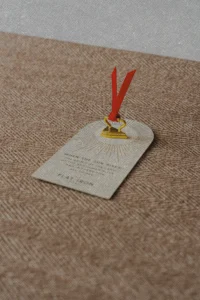 a golden iron token with a red ribbon, sitting on a bed at the Flat Iron Hotel