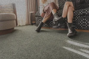 two girls sitting on a lounge sofa in a suite at the Flat Iron Hotel
