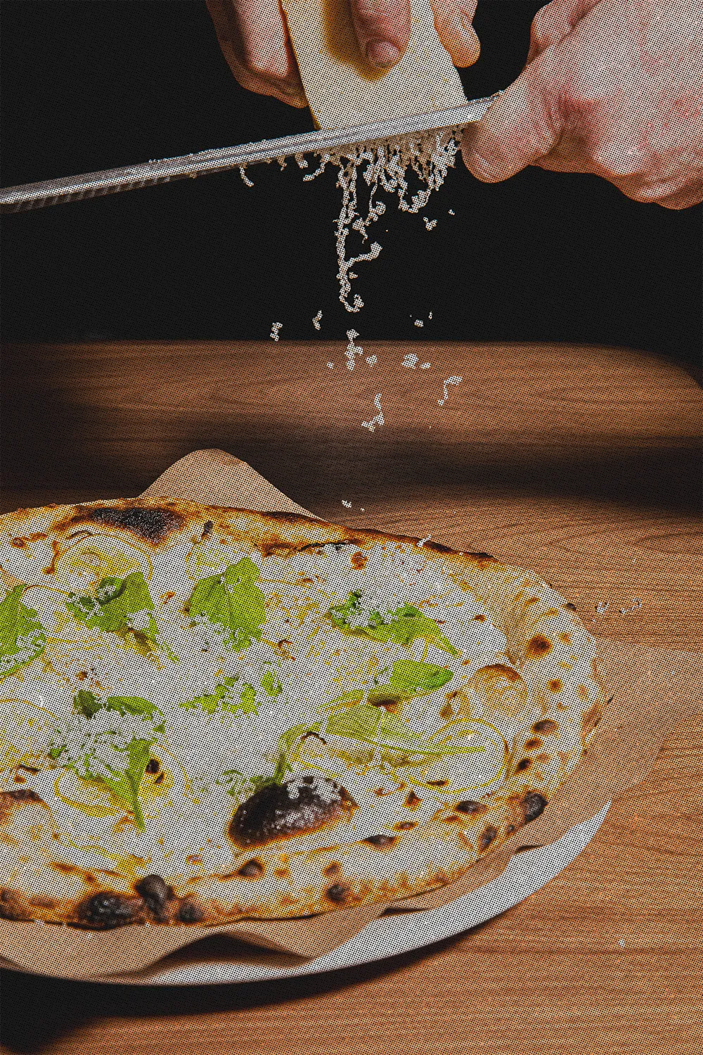 Cheese being grated on a lemon pizza at Luminosa