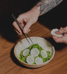 a chef plating a pasta dish from Luminosa with