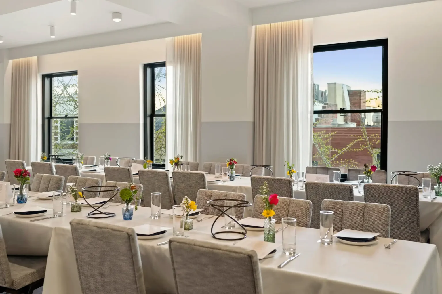 sunlit banquet tables set for a private lunch in the iron works lounge