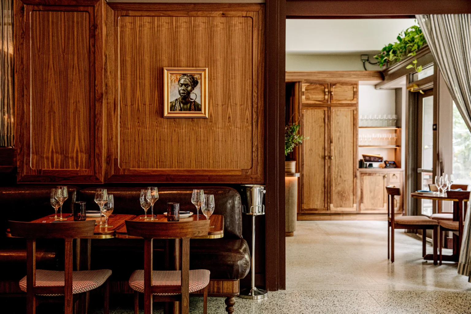 a suite of tables in Luminosa, with a framed painting of Nina Simone