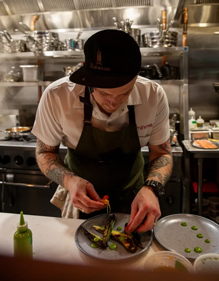Chef Graham House plating a dish at Luminosa