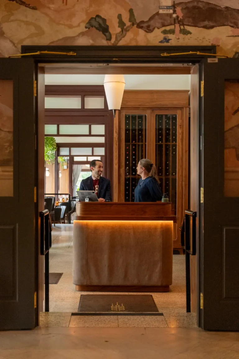 two hosts chat at the host stand at luminosa