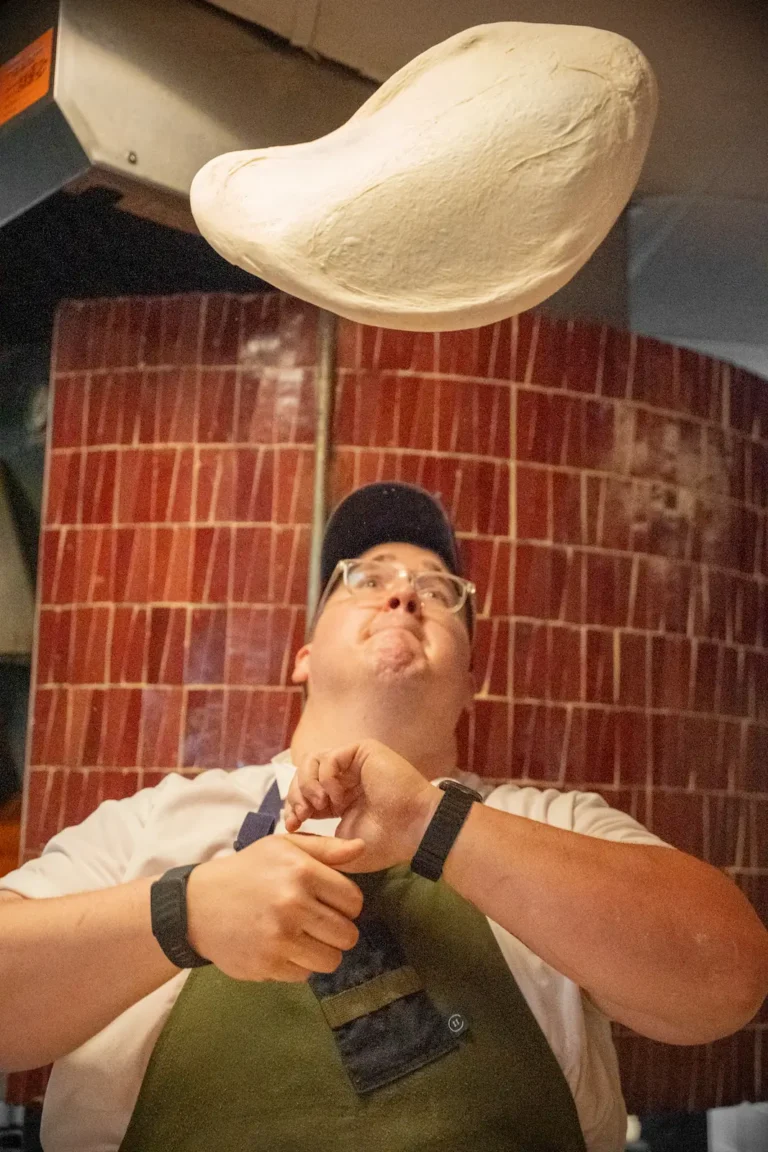 a chef at Luminosa tossing pizza dough