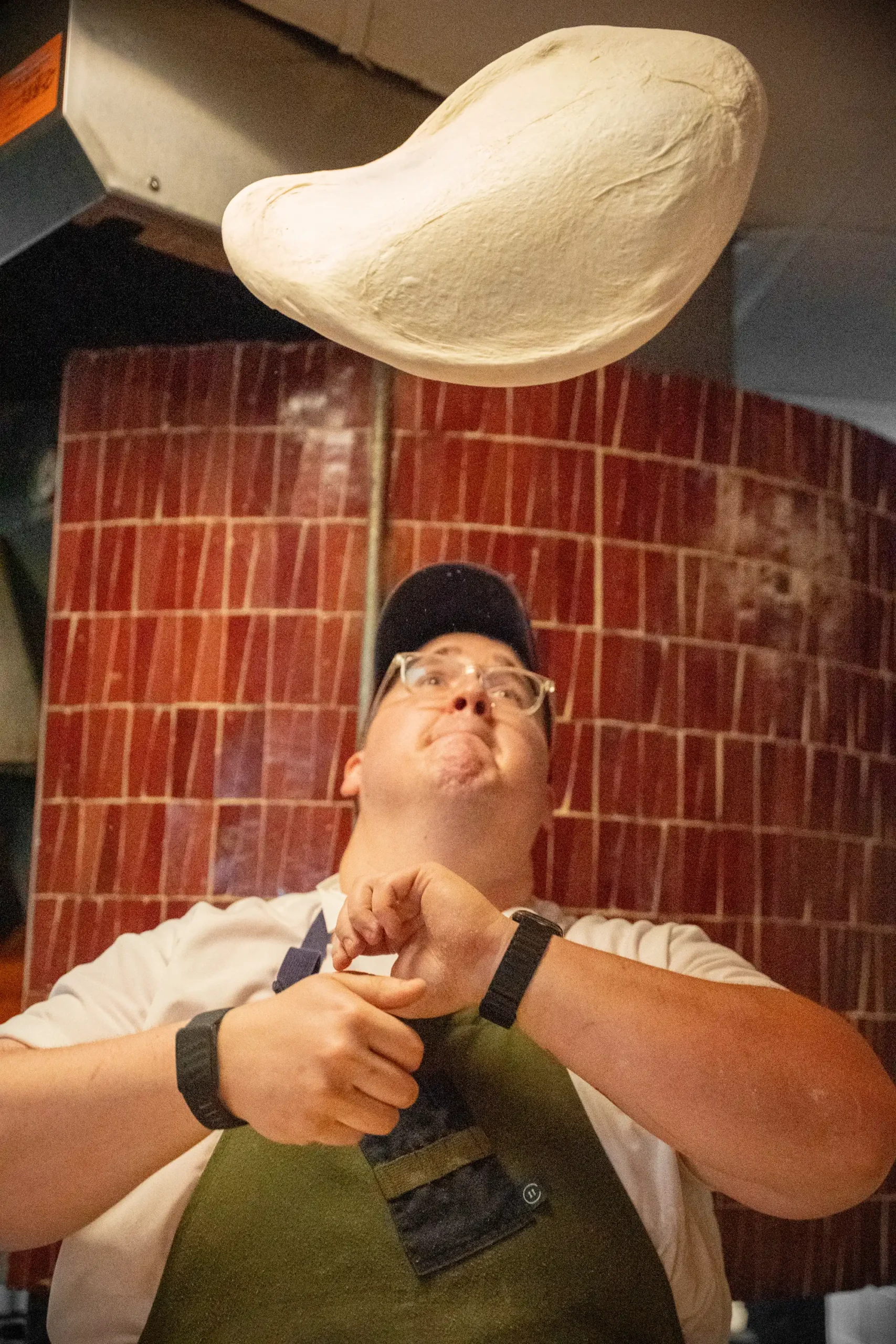 a chef at Luminosa tossing pizza dough