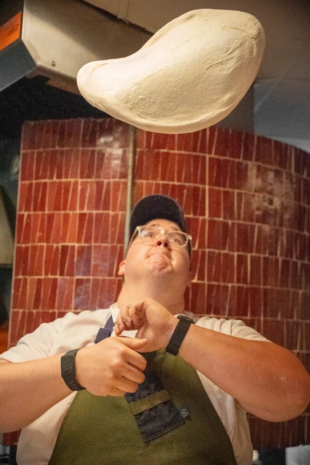 a chef at Luminosa tossing pizza dough