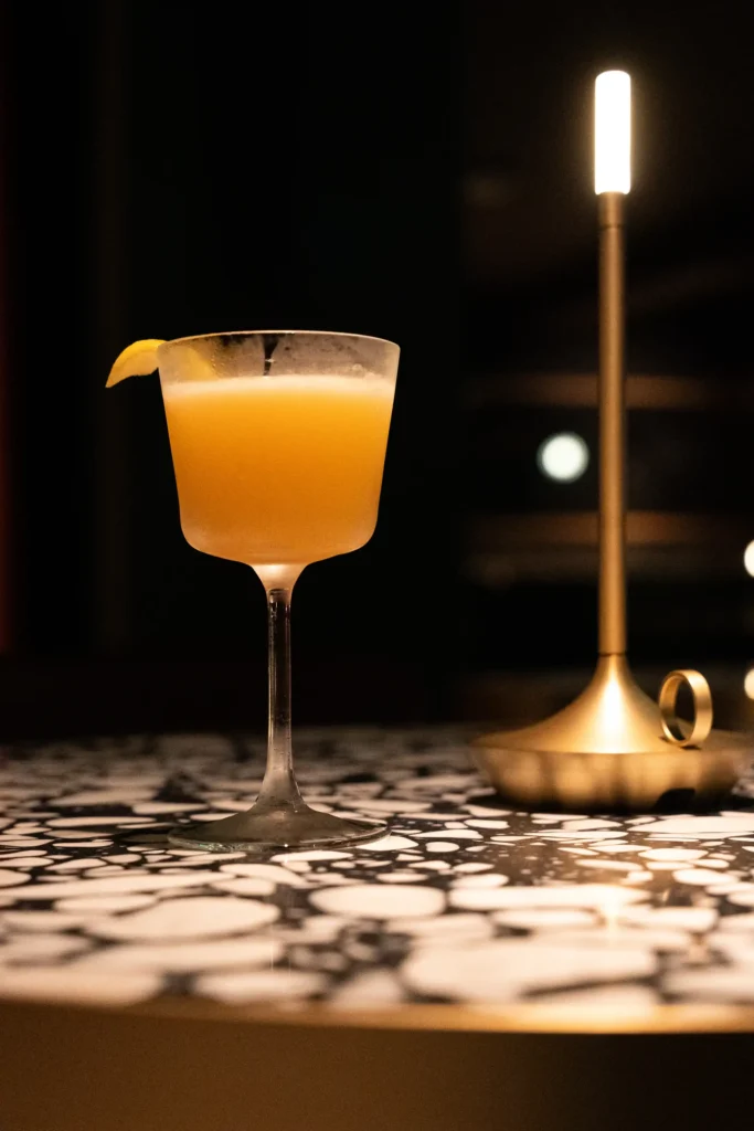 a cocktail drink in dim light at the red ribbon society bar
