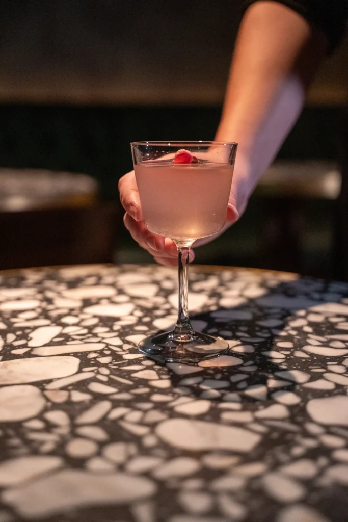 woman placing cocktail on table
