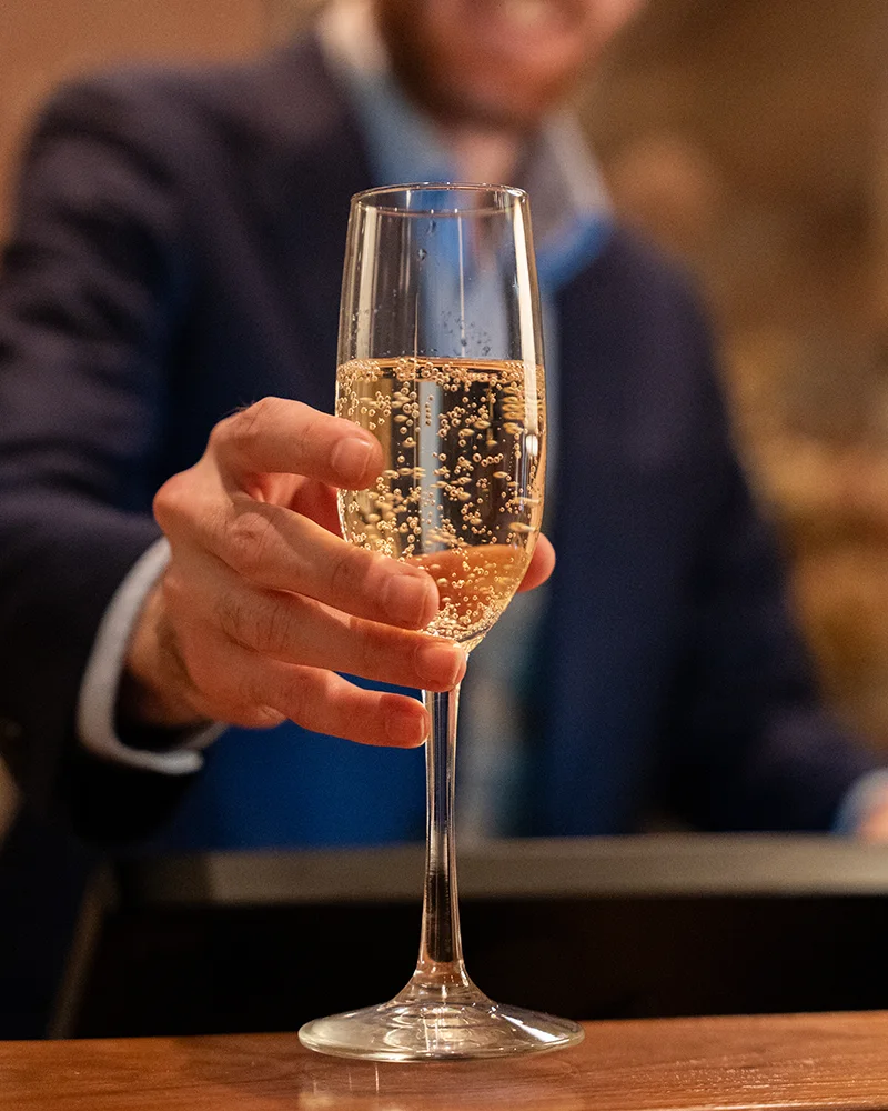 a hotel agent offers a glass of champagne