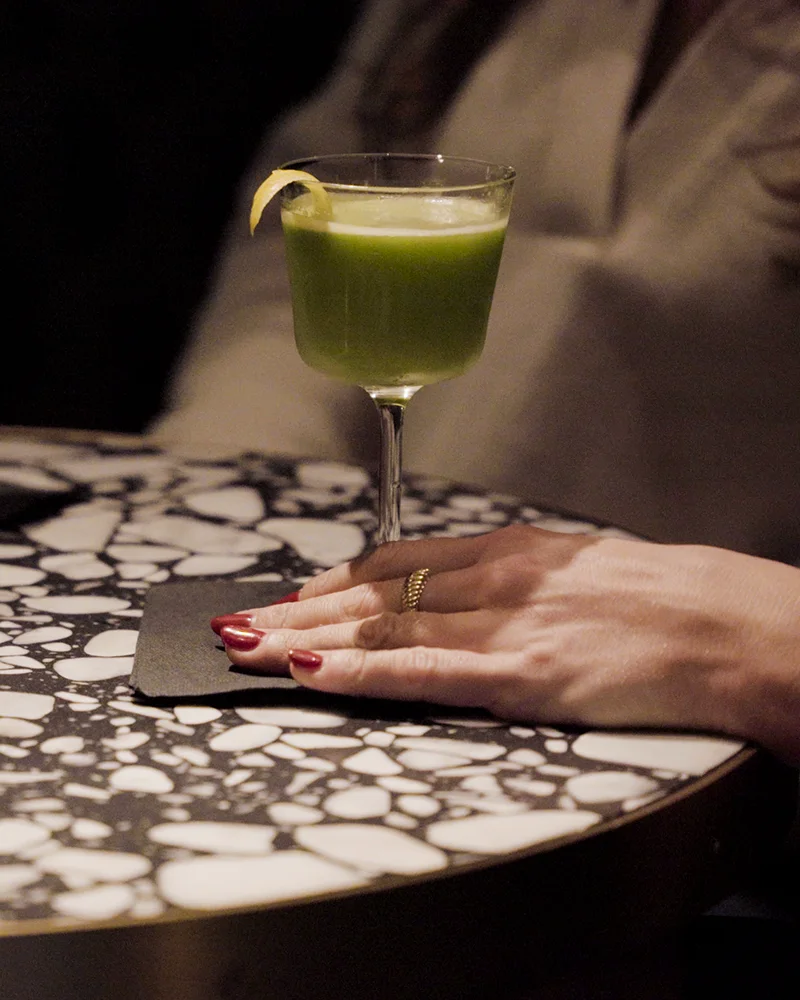 a woman holds a cocktail