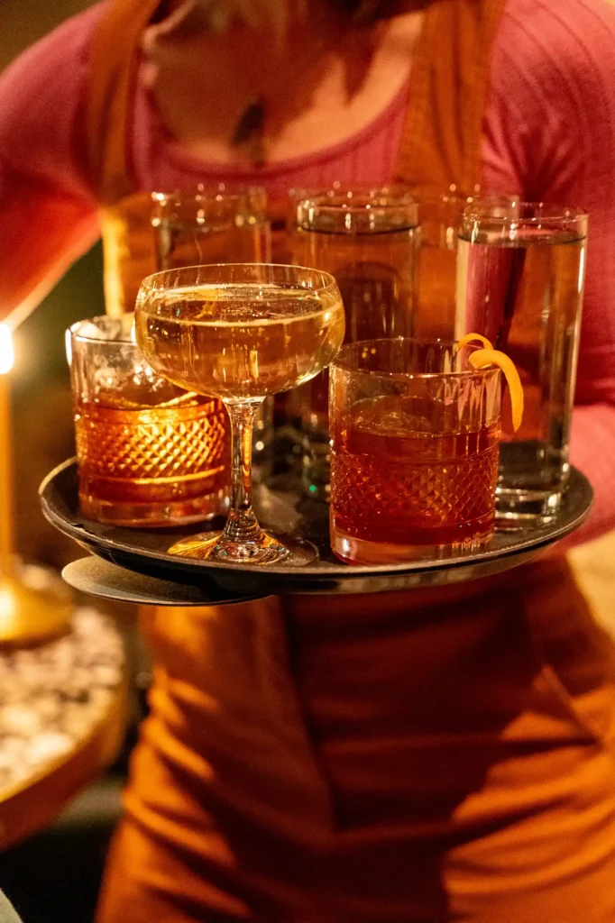 bartender carrying tray of cocktails