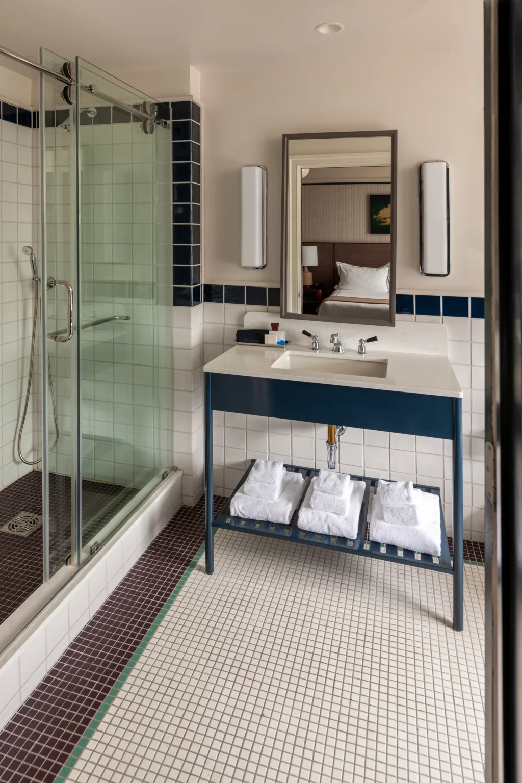 shower and vanity in a double queen room at the flat iron hotel