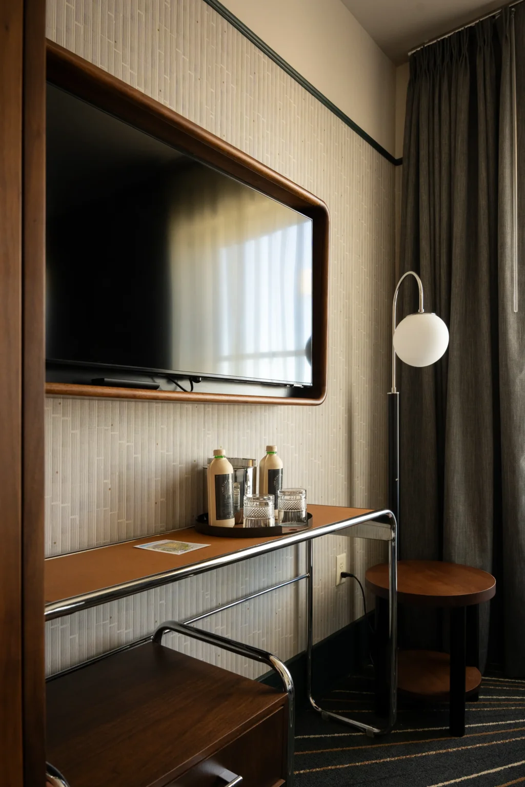king room, showing tv, table and whiskey glass set, at the flat iron hotel