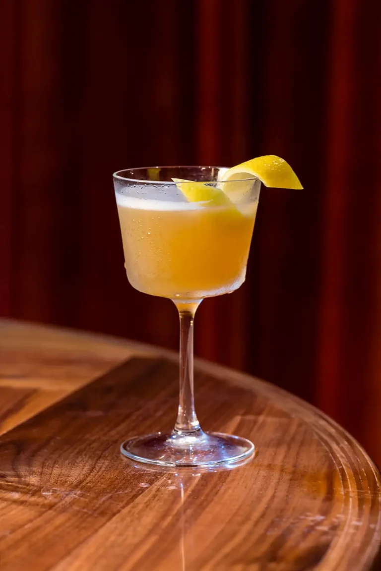 A Meet Cute cocktail with chickweed and a lemon garnish