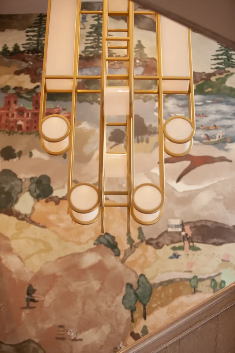 The art deco chandelier at the Flat Iron Hotel, with a whimsical Blue Ridge mural in the background