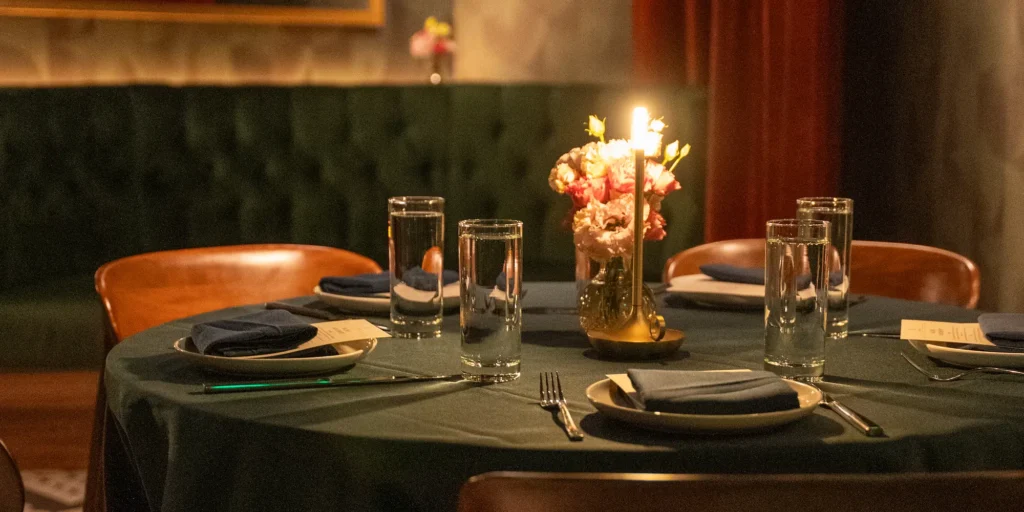 a candle light table setting at the red ribbon society at the flat iron hotel
