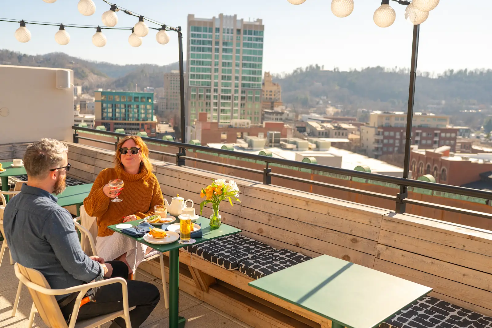 a couple enjoys breakfast on the city-facing patio
