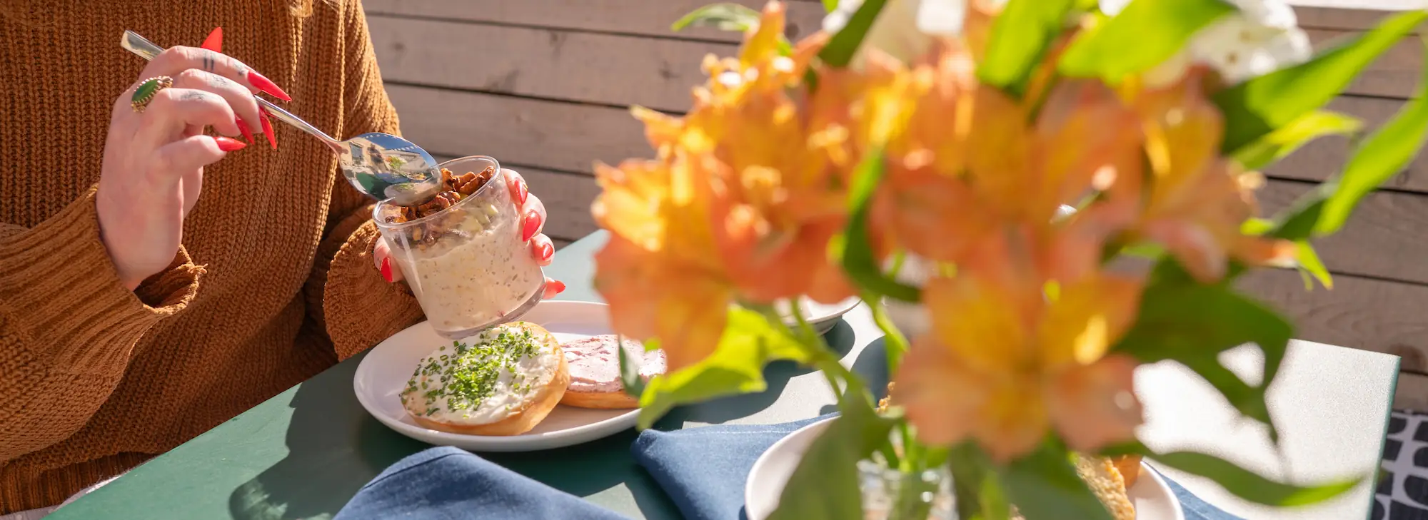a woman enjoys a parfait on the patio of the rooftop caffe