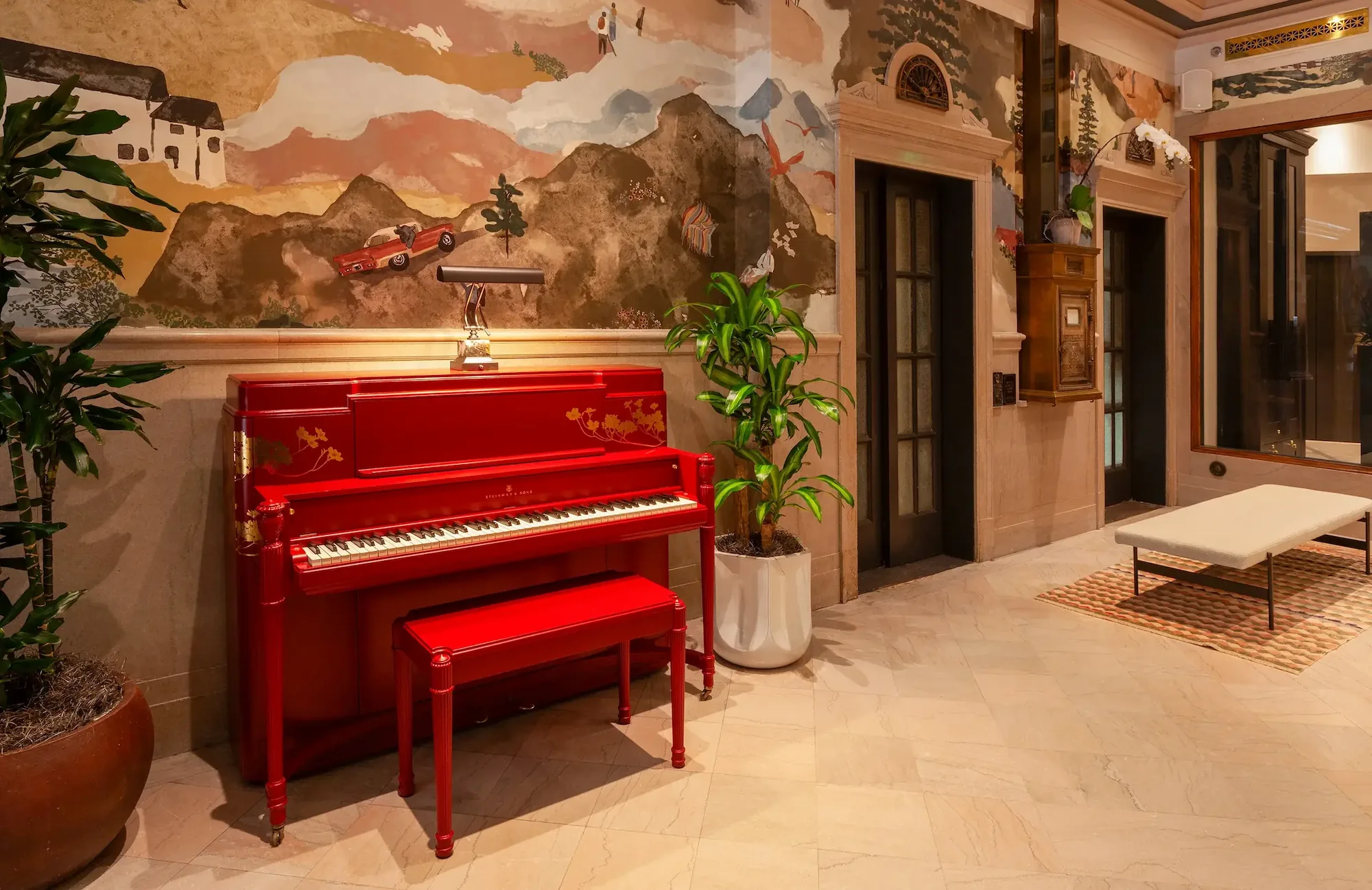 the lobby of the Flat Iron Hotel, with a red piano and historic elevators