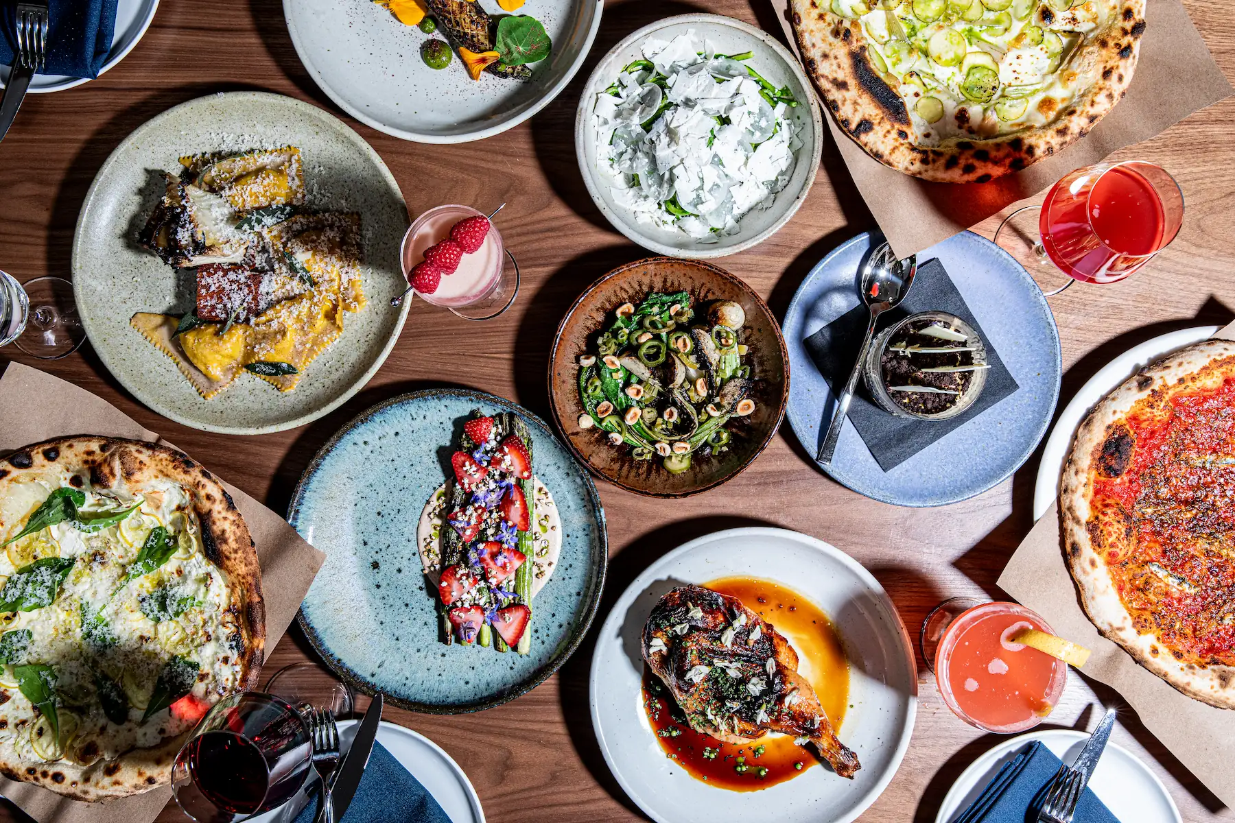 a spread of pastas, pizzas, wood-fired dishes, and cocktails